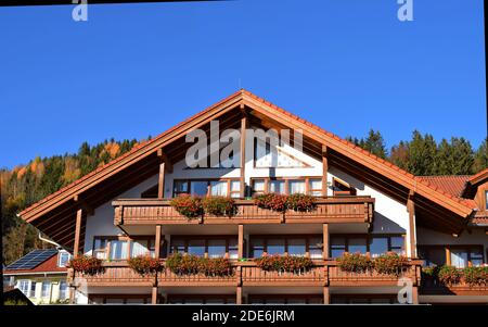 Hopfensee, BAVIÈRE, ALLEMAGNE - 03 novembre 2020: Ville avec bâtiments traditionnels bavarois et montagne des Alpes sur fond.décoré bavarois hou Banque D'Images