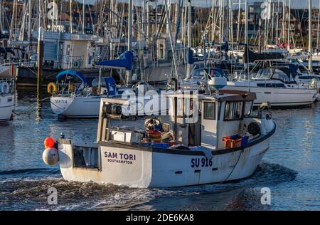 un petit chalutier de pêche côtière qui entre dans le port de lymington, dans la nouvelle forêt du hampshire. Banque D'Images