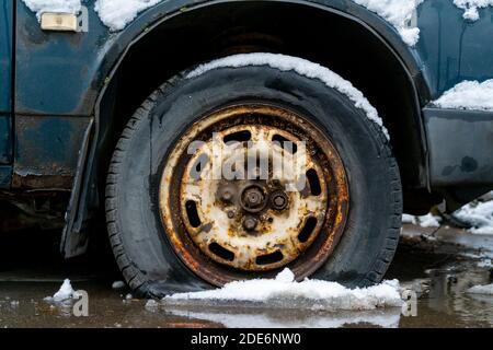 Moscou, Russie. 21 novembre 2020. Pneu crevé d'une vieille voiture dans la neige en hiver. Banque D'Images