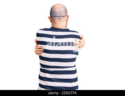 Jeune homme beau portant le masque cambrioleur se embrassant heureux et positif de l'arrière-plan. Amour de soi et soins de soi Banque D'Images