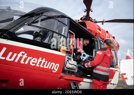 20 novembre 2020, Baden-Wuerttemberg, Rheinmünster: Gerhild Gruner (r), médecin urgentiste, et Patrick Bierherr, paramédical d'urgence, chargent du matériel de sauvetage dans l'hélicoptère de soins intensifs Christoph 111 de la DRF Stiftung Luftrettung gemeinnützige AG pendant une opération. Photo: Marijan Murat/dpa Banque D'Images