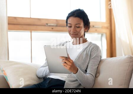 Une jeune femme afro-américaine utilise une tablette à la maison Banque D'Images