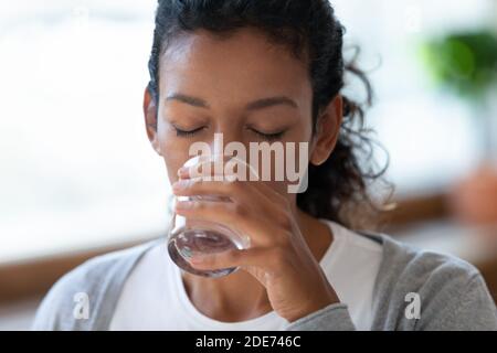 Femme biraciale déshydratée Profitez de l'eau propre du verre Banque D'Images
