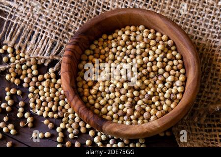 Graines de coriandre dans un bol en bois d'olive Banque D'Images