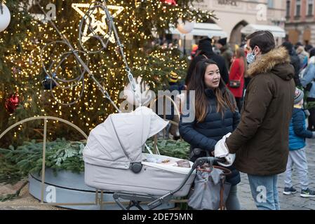 Prague, République tchèque. 29 novembre 2020. Un couple avec un stand de poussettes devant l'arbre de Noël. L'arbre de Noël a été illuminé sur la place de la vieille ville (Staromestske namesti) à Prague pendant le premier week-end de l'Avent. Le célèbre marché de Noël a été annulé en raison de la pandémie du coronavirus et des restrictions actuelles en République tchèque. Crédit : Tomas Tkacik/SOPA Images/ZUMA Wire/Alay Live News Banque D'Images