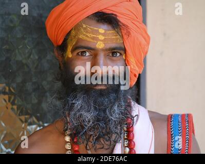 Le jeune homme Saint indien (sadhu, baba, guru) et yogi avec de la pâte de bois de santal jaune tripundra sur son front pose pour la caméra pendant Maha Shivaratri. Banque D'Images