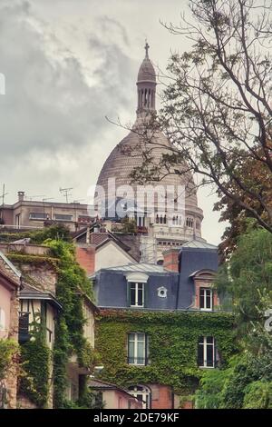 Belles maisons situées dans le quartier de Montmartre, avec la basilique du coeur sacré en arrière-plan Banque D'Images