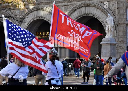 Washington DC. 14 novembre 2020. La marche de Mages. Les femmes avec le drapeau américain et le drapeau « Trump Keep America Great » devant Trump International Hotel. Banque D'Images