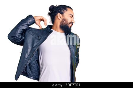 Jeune homme arabe portant une veste de cuir décontractée souffrant de blessures de mal de cou, touchant le cou avec la main, douleur musculaire Banque D'Images