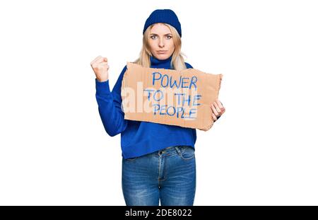 La jeune femme caucasienne qui tient le pouvoir sur la bannière du peuple a énervé et frustré criant avec colère, hurlant fou avec colère et la main levée Banque D'Images