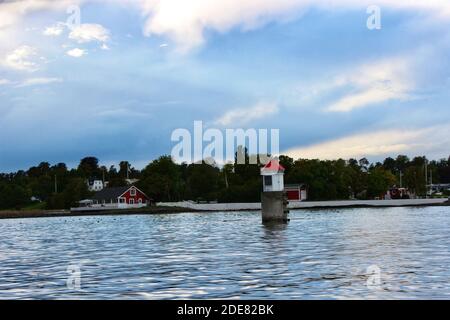 Poteau en béton avec petite maison avec toit rouge en haut Eau de mer juste à côté d'un fjord à l'extérieur d'Oslo Banque D'Images