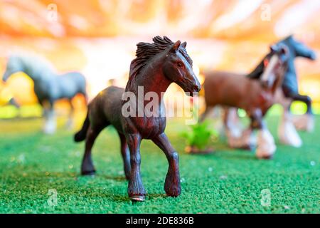 figurines en plastique de chevaux sauvages sur fond orange. jouets d'enfants. concept de protection des animaux Banque D'Images