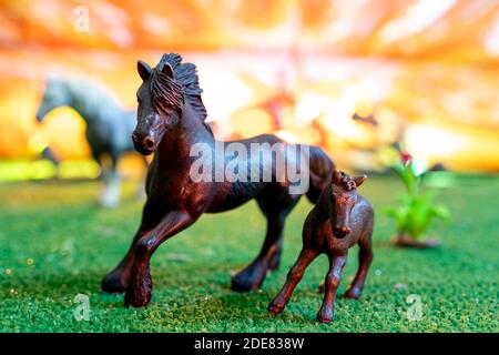 figurines en plastique de chevaux sauvages sur fond orange. jouets d'enfants. concept de protection des animaux Banque D'Images