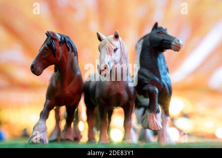 figurines en plastique de chevaux sauvages sur fond orange. jouets d'enfants. concept de protection des animaux Banque D'Images