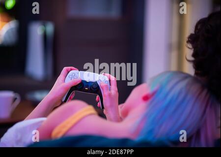 Moscou - novembre 28 2020 : une femme tient à la maison la manette de commande Dualsense de la console de jeu PlayStation 5 de Sony. Jouer avec elle Banque D'Images