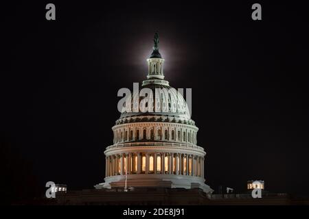 Washington, États-Unis. 27 janvier 2020. Une pleine lune s'élève derrière le Capitole des États-Unis à Washington, DC, le 29 novembre 2020, dans le contexte de la pandémie du coronavirus. Bien qu'obscurcie par des nuages de lumière, la pleine lune de novembre 29-30 était accompagnée d'une éclipse lunaire pénombre, ce qui a causé l'apparition d'une lune légèrement plus sombre. (Graeme Sloan/Sipa USA) Credit: SIPA USA/Alay Live News Banque D'Images