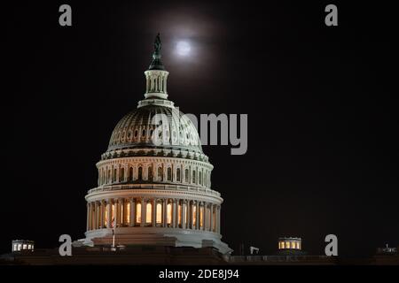 Washington, États-Unis. 29 novembre 2020. Une pleine lune s'élève derrière le Capitole des États-Unis à Washington, DC, le 29 novembre 2020, dans le contexte de la pandémie du coronavirus. Bien qu'obscurcie par des nuages de lumière, la pleine lune de novembre 29-30 était accompagnée d'une éclipse lunaire pénombre, ce qui a causé l'apparition d'une lune légèrement plus sombre. (Graeme Sloan/Sipa USA) Credit: SIPA USA/Alay Live News Banque D'Images