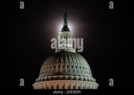 Washington, États-Unis. 29 novembre 2020. Une pleine lune s'élève derrière le Capitole des États-Unis à Washington, DC, le 29 novembre 2020, dans le contexte de la pandémie du coronavirus. Bien qu'obscurcie par des nuages de lumière, la pleine lune de novembre 29-30 était accompagnée d'une éclipse lunaire pénombre, ce qui a causé l'apparition d'une lune légèrement plus sombre. (Graeme Sloan/Sipa USA) Credit: SIPA USA/Alay Live News Banque D'Images