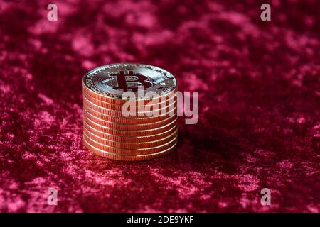 Pile de bitcoins d'or sur fond de velours rouge Banque D'Images