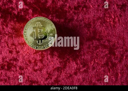 Pile de bitcoins d'or sur fond de velours rouge Banque D'Images