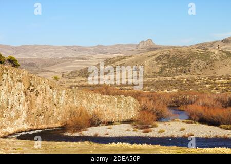 Rivière traversant la steppe patagonienne à Neuquen, en Argentine, près de la chaîne de montagnes des Andes. Banque D'Images