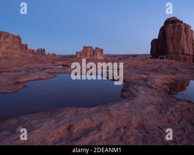 Les tours du palais de justice et les trois formations de Gossips Rock dans le parc national d'Arches dans l'Utah pendant l'heure bleue. Banque D'Images