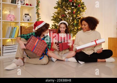 Enfants ouvrant Noël cadeaux Banque D'Images