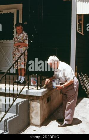 Photo des années 1970 (1975) - le porche reçoit une couche de peinture dans une maison de Boomer West Virginia occupée par le couple âgé dans la photo. Banque D'Images