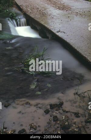 Photos des années 1970 (1973) - les sols argileux peu profonds et les terres mal reliées posent un problème d'érosion chaque fois que de fortes pluies tombent. Ici, le limon entre dans un ruisseau à l'ouest de Gravois Mills lors d'une pluie battante (région du lac Ozarks Missouri) Banque D'Images