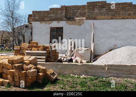 Une pile de briques se trouve devant la maison en cours de construction. Banque D'Images