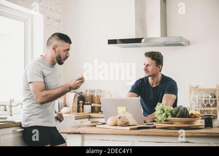 Un couple gay masculin parle sérieusement à la maison tout en faisant les routines du matin, le concept de style de vie LGBT Banque D'Images