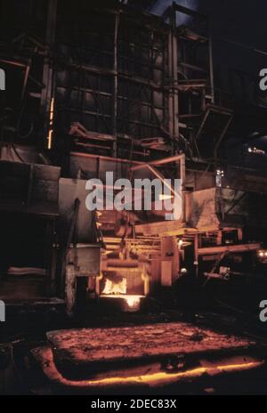 Photo des années 1970 (1975) - le métal refroidit au premier plan tandis que le four a été taraudé et est prêt à verser à l'usine de ferro-alliage Union Carbide. Banque D'Images