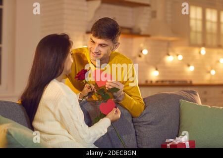 L'homme donne une rose, un cadeau et des Saint-Valentin à sa femme bien-aimée en l'honneur de la Saint-Valentin. Banque D'Images