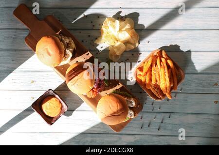 Photo en gros plan d'un hamburger maison avec de la bière faite de boeuf, d'oignon, de tomate, de laitue, de fromage et d'épices. Hamburger frais sur table rustique en bois Banque D'Images