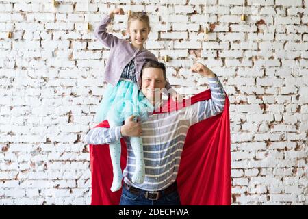 heureux père en costume de super-héros et sa fille Banque D'Images