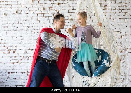heureux père en costume de super-héros et sa fille Banque D'Images