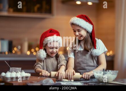 Joyeux Noël et joyeuses fêtes. Préparation familiale repas de vacances.Sœurs cuisinant des biscuits. Banque D'Images