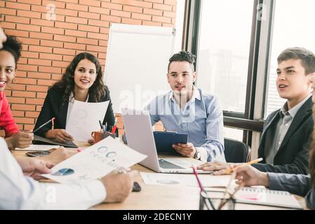 Groupe d'associés d'affaires du millénaire hommes et femmes au travail d'équipe réunion à l'écoute attentive des collègues qui donnent la présentation Banque D'Images