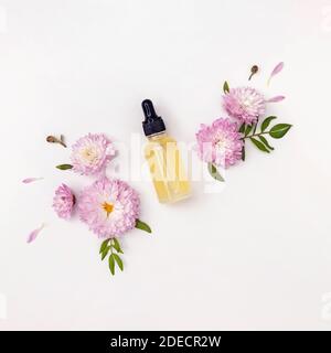 Composition avec sérum facial ou huile essentielle et fleurs Banque D'Images