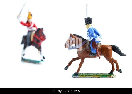 Photo de soldats en étain faits à la main sur des chevaux sur le blanc arrière-plan Banque D'Images