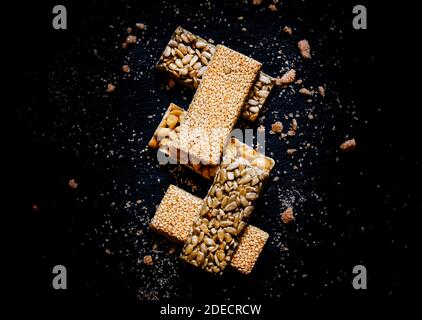 Graines de sésame, tournesol et arachides au caramel, fond de nourriture sombre, foyer sélectif Banque D'Images