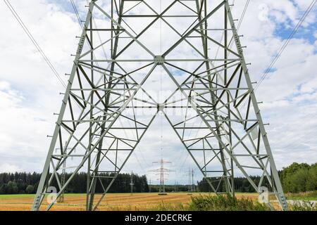 Oberbrunn, Allemagne - 23 août 2020 : vue à travers et le long d'une ligne électrique aérienne. Symbole pour l'énergie, la transmission d'énergie et le réseau électrique. Banque D'Images
