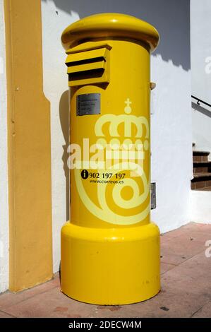 Boîte postale traditionnelle jaune espagnole dans le centre du village, Benahavis, Espagne. Banque D'Images