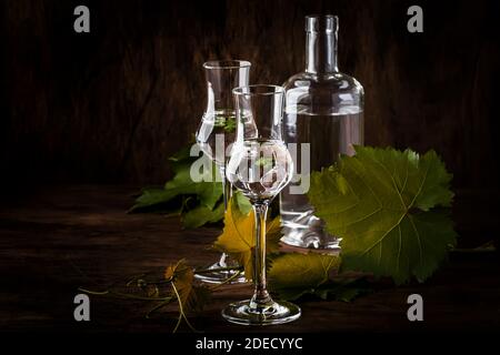 Vodka au raisin, pisco - boisson alcoolisée péruvienne traditionnelle forte dans des verres élégants sur une table en bois d'époque, espace de photocopie Banque D'Images