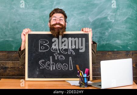 Enseignant ou directeur d'école accueille avec tableau noir inscription retour à l'école. Bienvenue à nouveau. Début de nouvelle année scolaire en septembre. Enseignant accueille de nouveaux élèves à entrer dans l'établissement d'enseignement. Banque D'Images