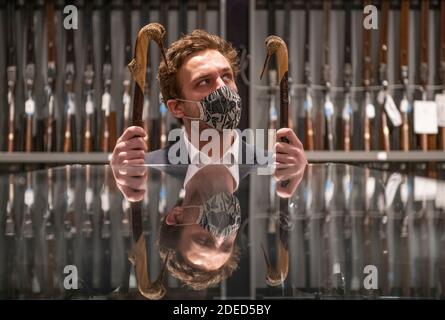 Knightsbridge, Londres, Royaume-Uni. 30 novembre 2020. Aperçu de la vente d'armes anciennes, d'armes de sport modernes et d'armes à feu exceptionnelles de Bonhams à Londres. La vente aura lieu le 3 décembre. Image: Membre du personnel de Bonhams avec deux équipes sportives sculptées par Ian Jones estime £500-700. Crédit : Malcolm Park/Alay Live News Banque D'Images