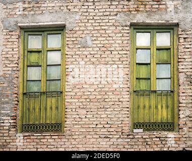 vieilles fenêtres vertes sur un mur de briques Banque D'Images