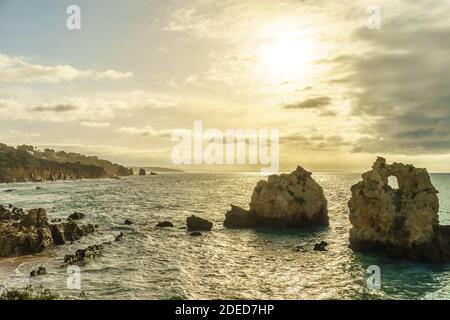 Belle vue sur l'océan Atlantique horizon avec plage de sable, rochers et vagues au lever du soleil. Banque D'Images