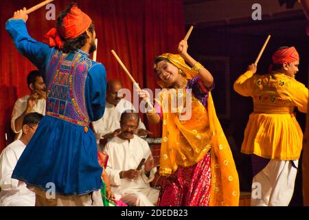 Un groupe de danseurs folkloriques donne un spectacle à Mumbai, en Inde, en agitant des cannes et portant des costumes colorés Banque D'Images