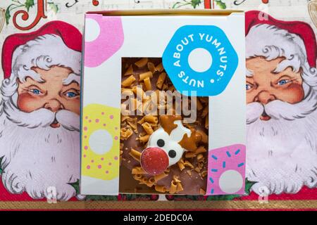 Rudolph le Donut à nez rouge dans une boîte fraîche de la boulangerie Chez Marks & Spencer, mettez la serviette de Noël à la serviette Banque D'Images